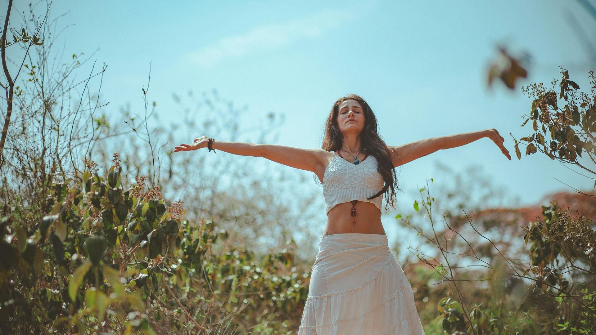 A calm and focused person in a yoga pose in a dark, serene environment.